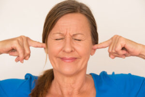 image of homeowner covering ears due to air conditioner noises