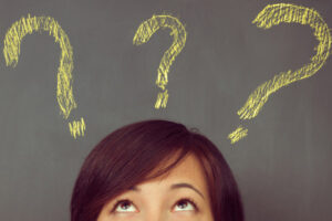 image of woman with question marks depicting condensing vs evaporator coils on an air conditioner