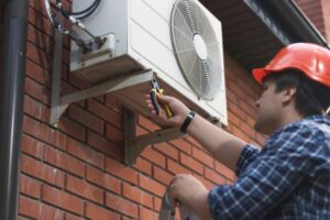 Professional worker replacing outdoor AC unit