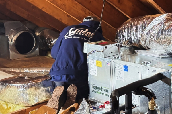 Wilcox Energy technician installing new ducts for air conditioning system