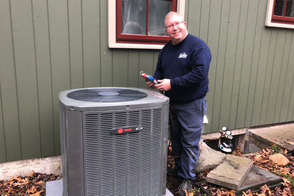 Wilcox Energy HVAC technician refilling air conditioner refrigerant