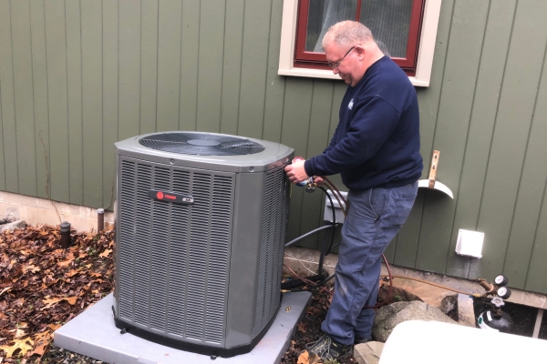 outdoor HVAC unit being professionally serviced by Wilcox Energy depicting compressor motor