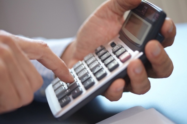 man holding calculator depicting HVAC load calculation