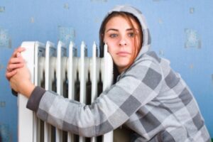 girl hugging an indoor heating radiator depicting emergency heating repair